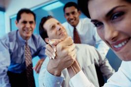 A group of people in business attire holding hands.