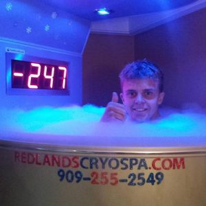 A man in an ice bath with the time displayed.